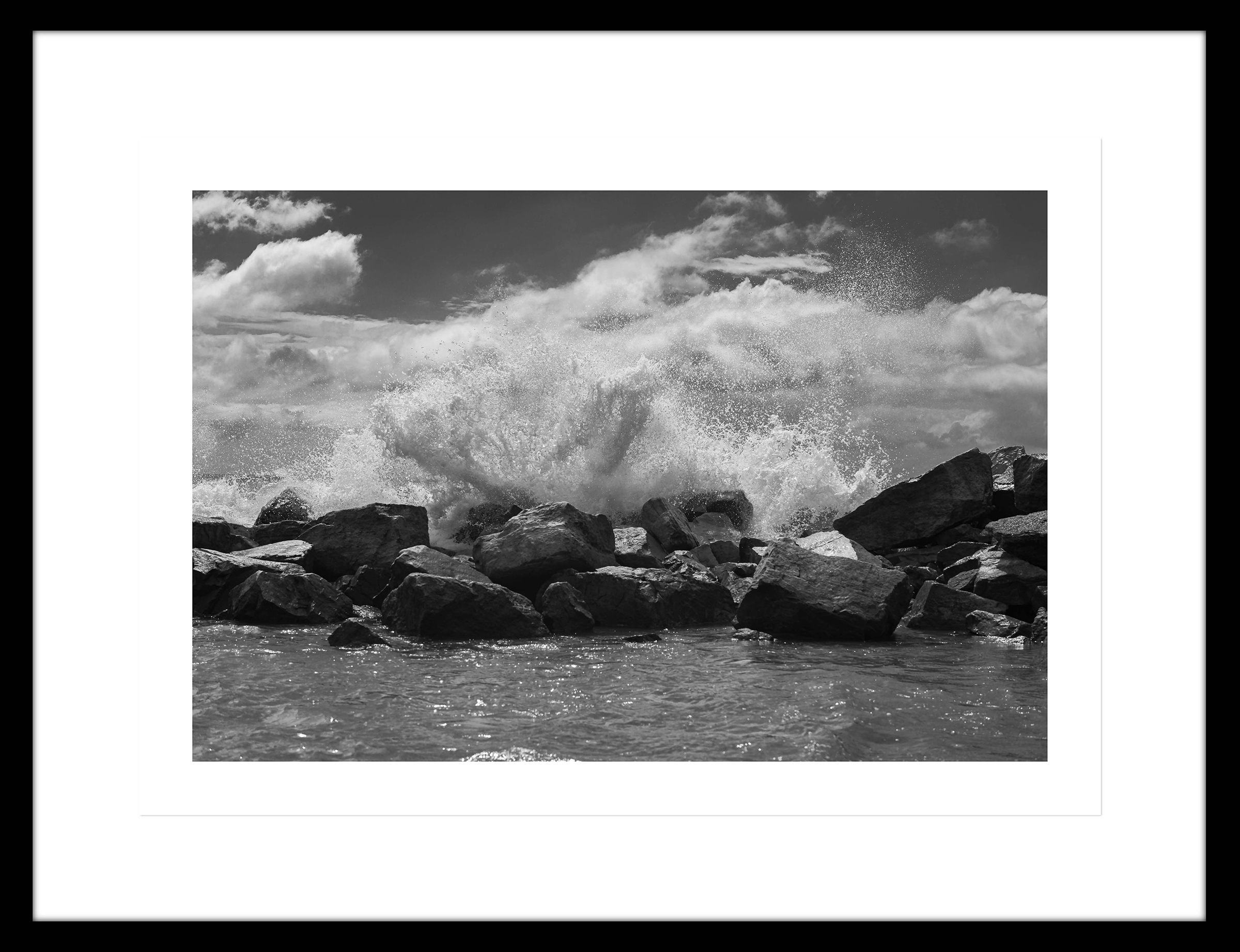 Ampliación de una fotografía de la las olas rompiendo contra una barrera de rocas