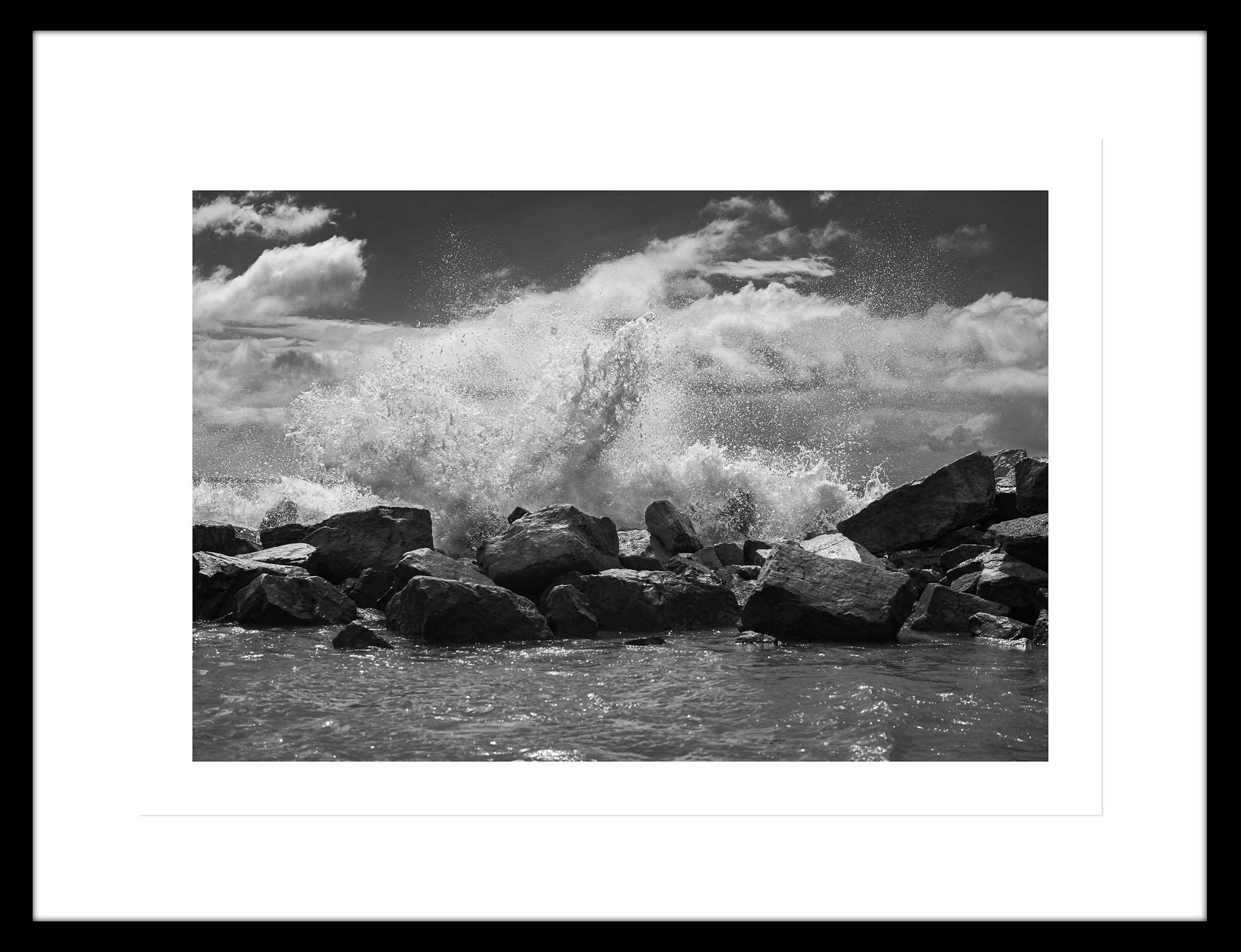 Ampliación de la fotografía de la fuerza de las olas rompiendo contra las rocas
