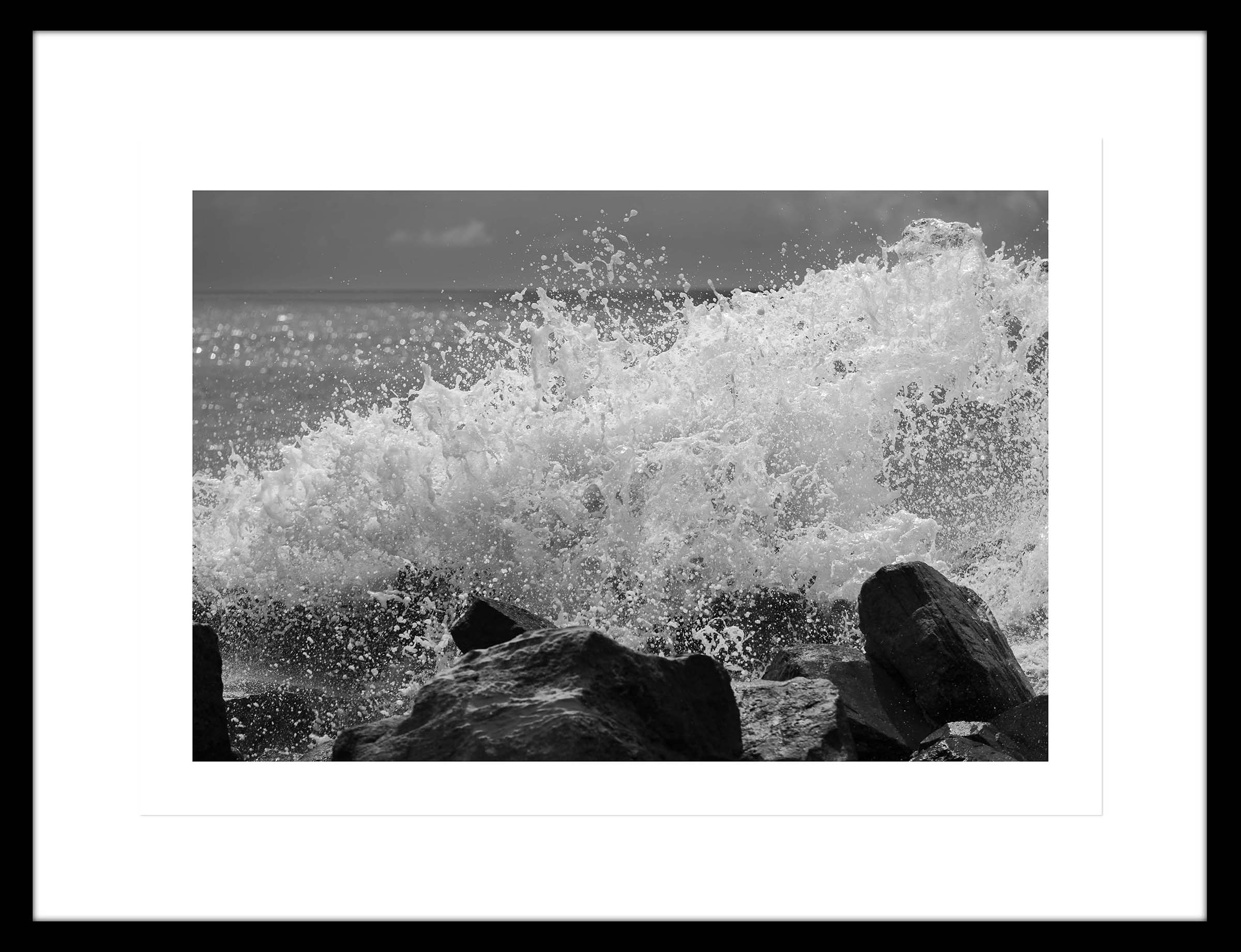 Ampliación de la fotografia de la espuma y las formas formadas por una ola al romper contra las rocas