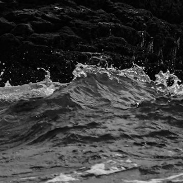 Fragmento de la fotografia de la potencia del mar al estrellarse contra las rocas de la costa